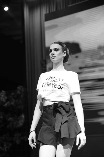 Una foto in bianco e nero di una donna che cammina su una passerella.