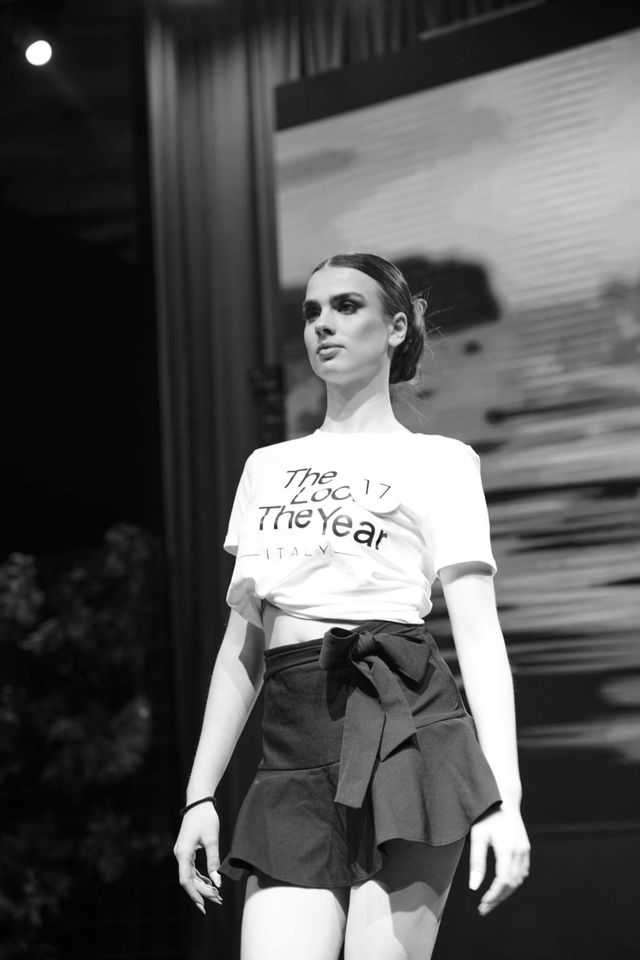 Una foto in bianco e nero di una donna che cammina su una passerella.
