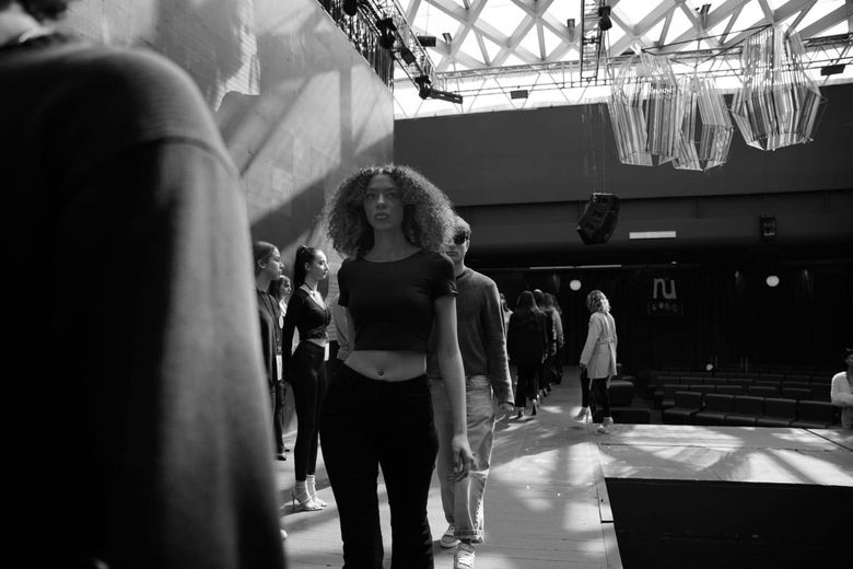 Una foto in bianco e nero di un gruppo di persone in piedi in una stanza.