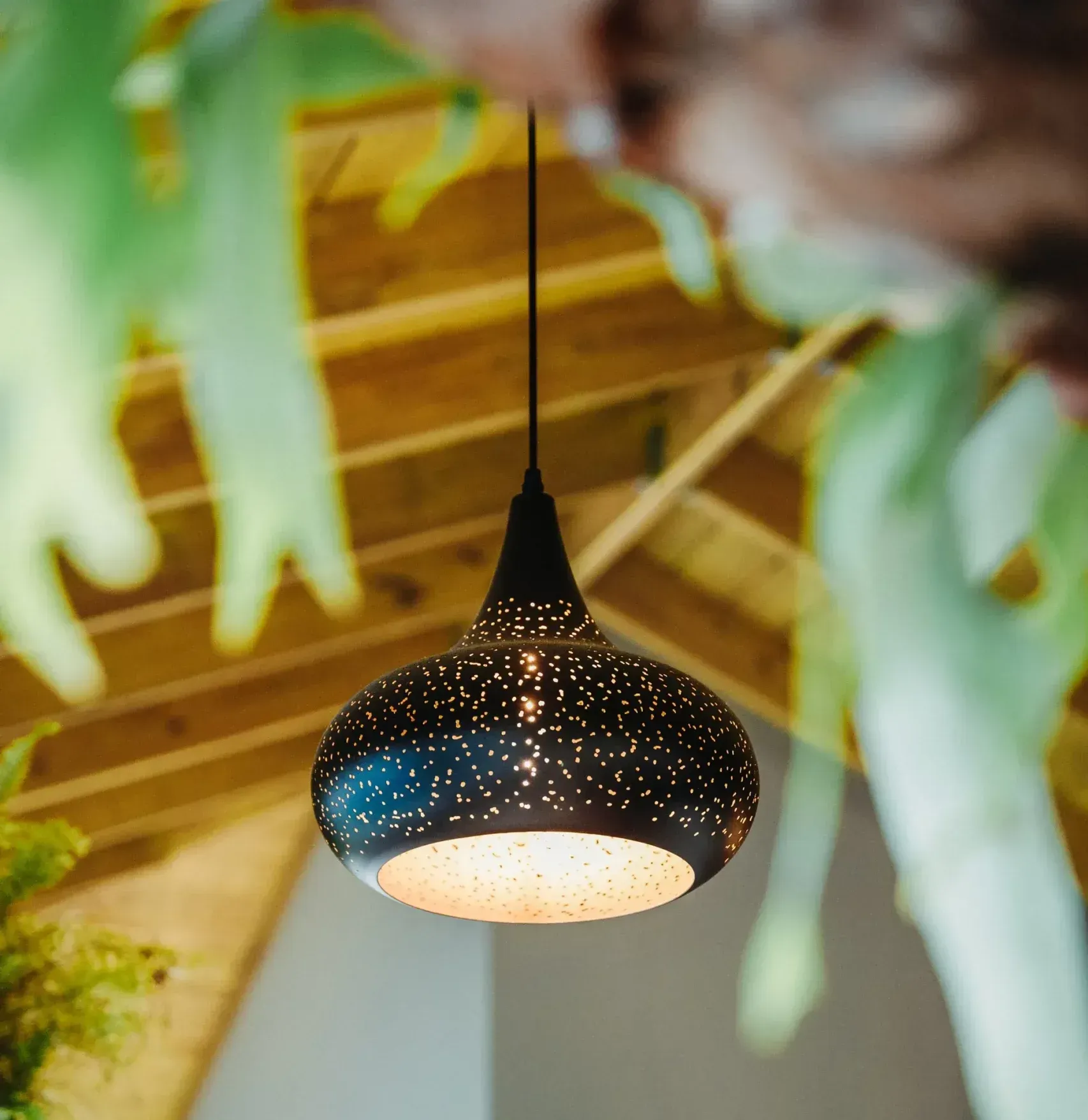 A pendant light is hanging from a wooden ceiling