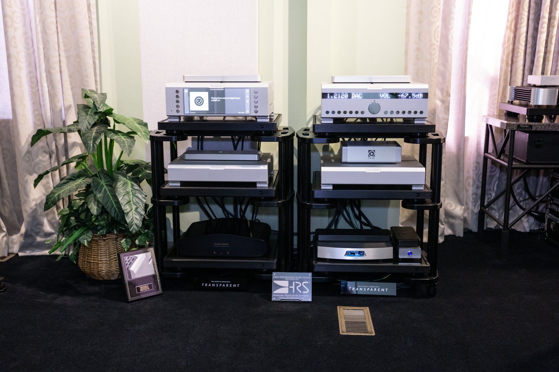 Listening room with stereo equipment, plants, artwork, and a sofa; orange walls, blue carpet.