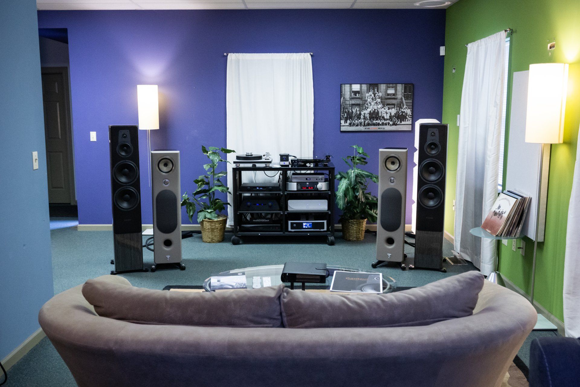 Living room with blue and green walls, stereo speakers, sofa, audio equipment.