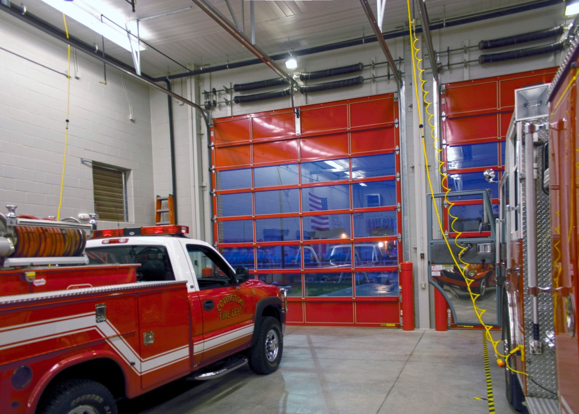 a red and white fire truck is parked in a garage