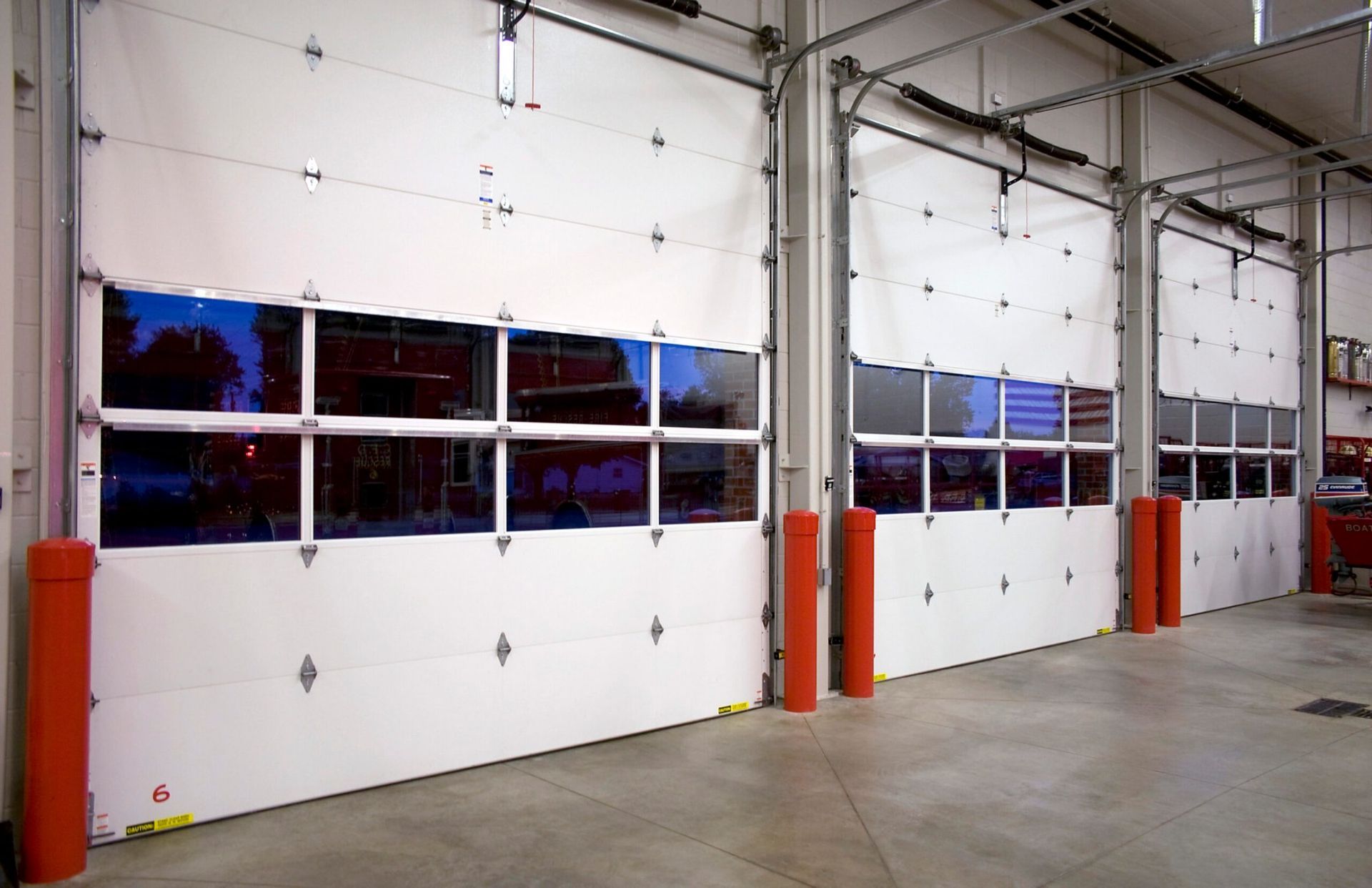 a row of white garage doors with a lot of windows
