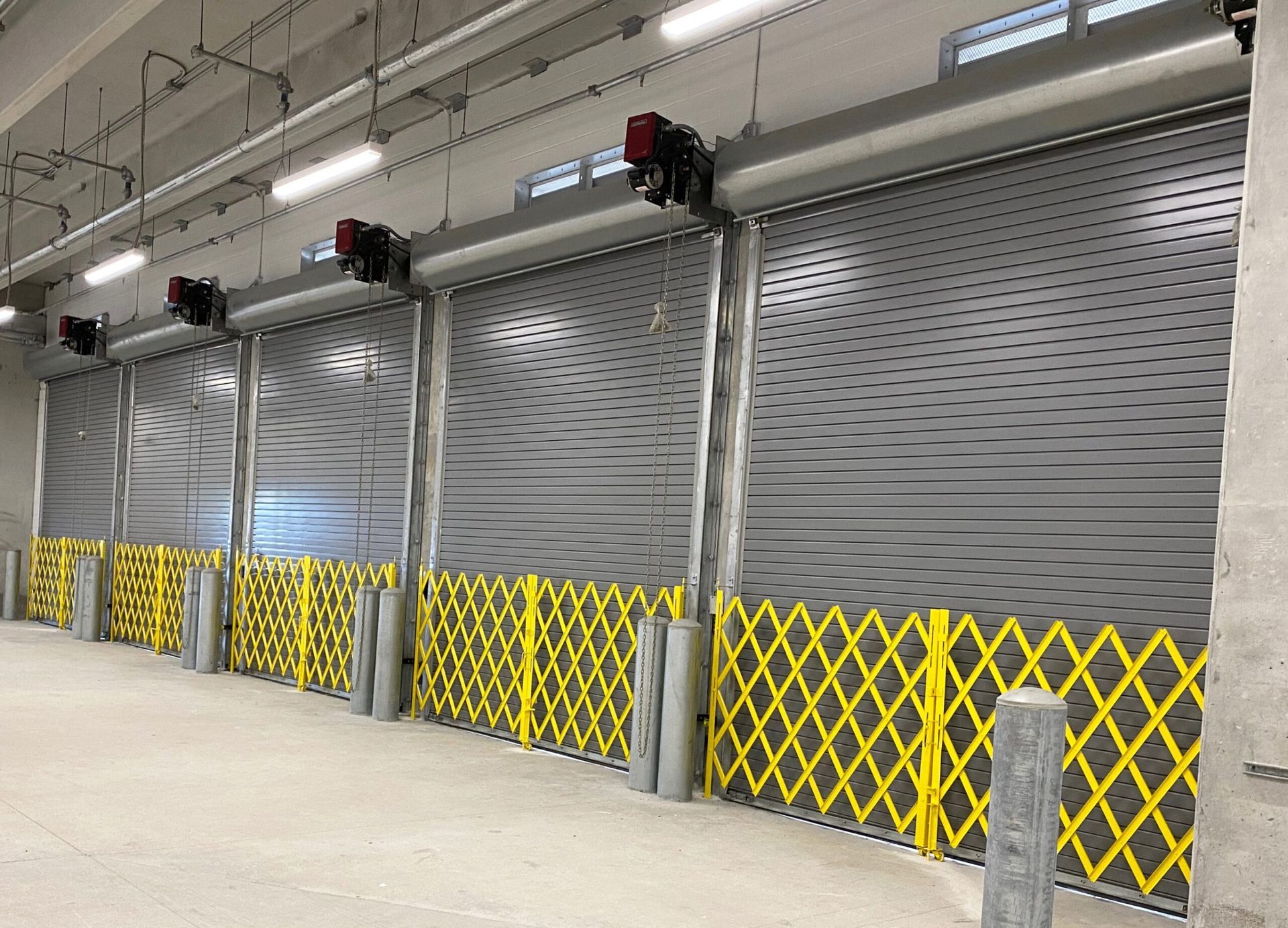 a row of garage doors with a yellow barrier between them .