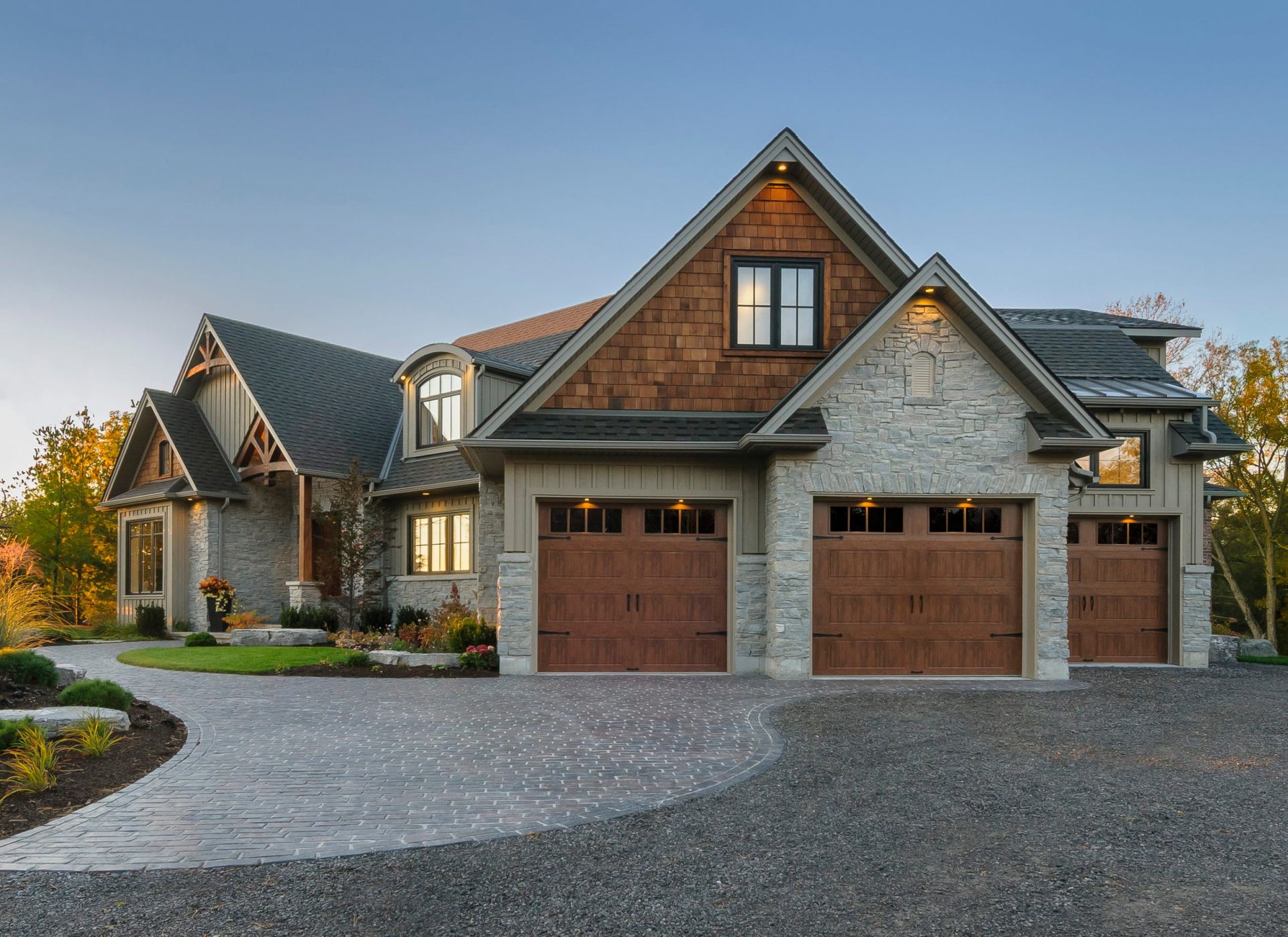 a large house with two garage doors and a driveway in front of it .