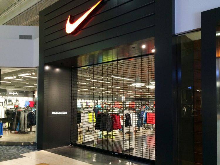 a nike store in a shopping mall with a sliding glass door