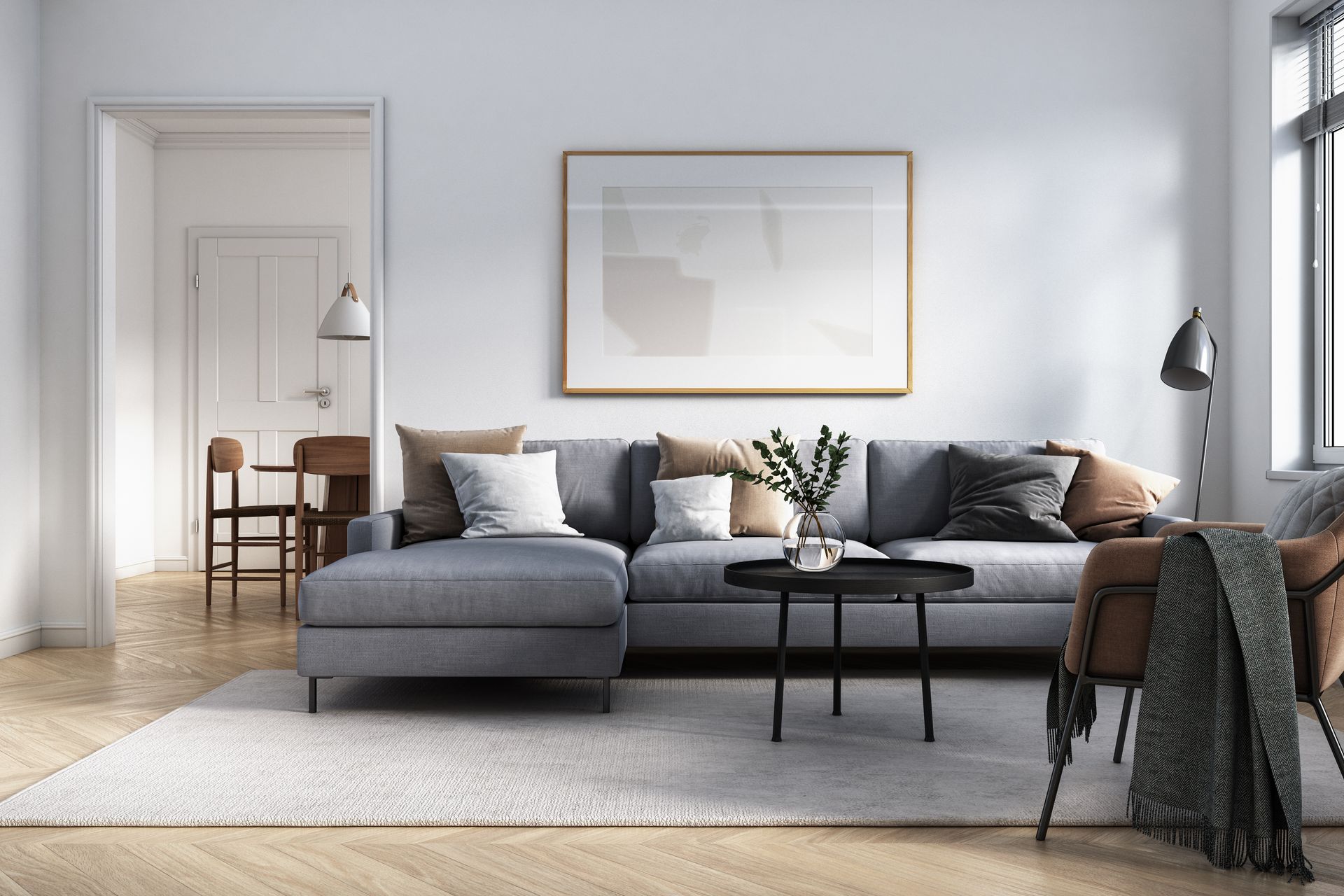 Soggiorno con divano componibile grigio, tavolino da caffè, quadri con cornice e pavimenti in legno.
