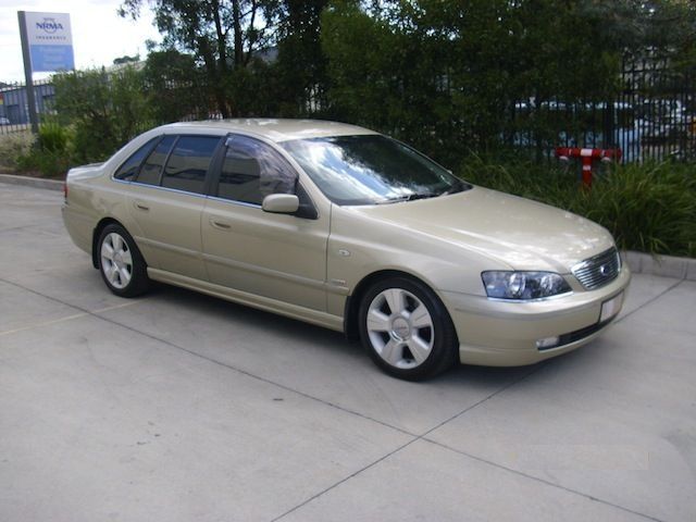 A gold car is parked in a parking lot