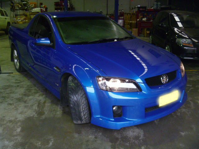 A blue pickup truck is parked in a garage