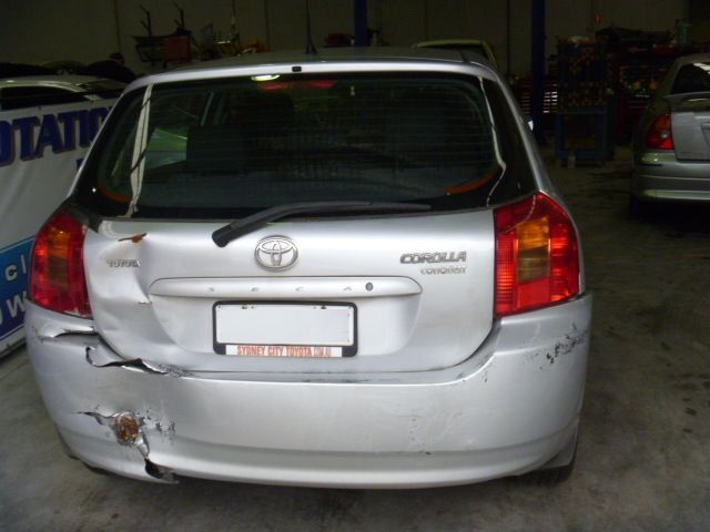 A silver toyota corolla is parked in a garage