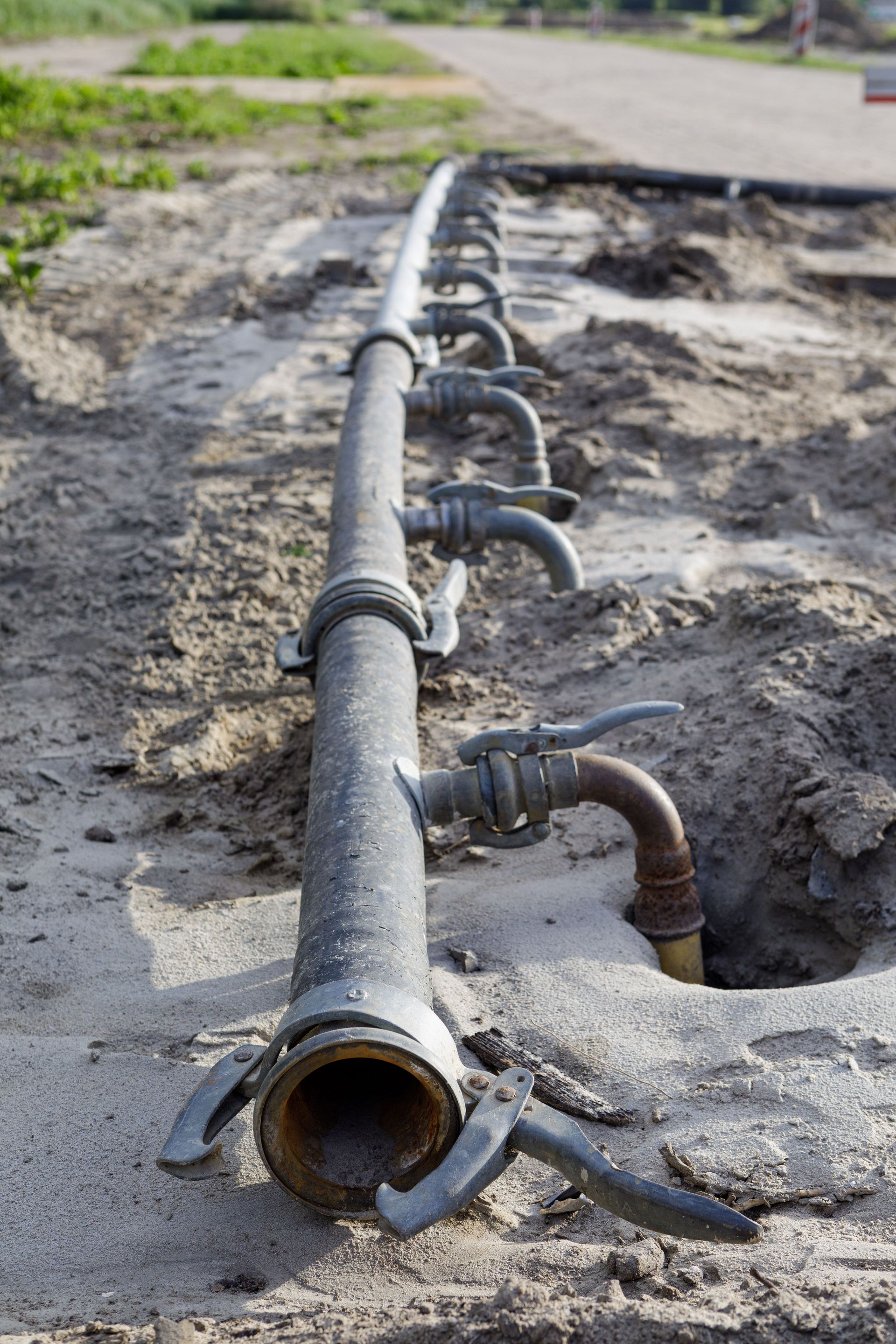 closeup-of-irrigation-pipes-in-a-muddy-field