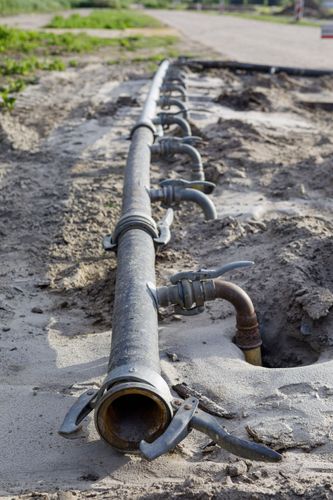 closeup-of-irrigation-pipes-in-a-muddy-field
