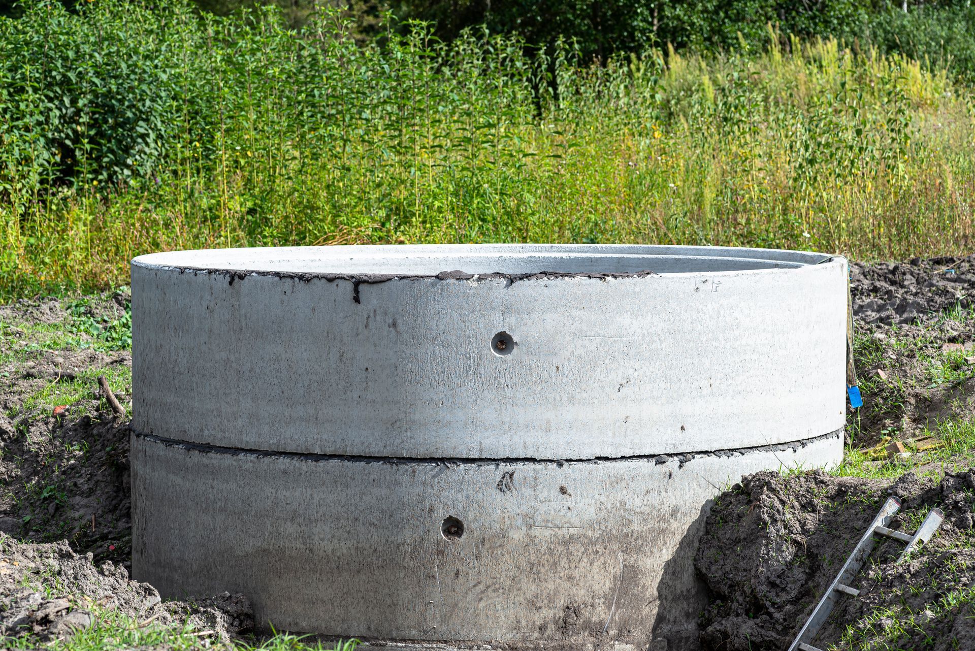 Concrete septic tank rings installed in ground showing professional local septic system installation