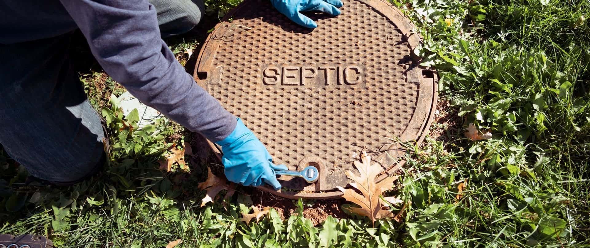 worker opening up sewer drain