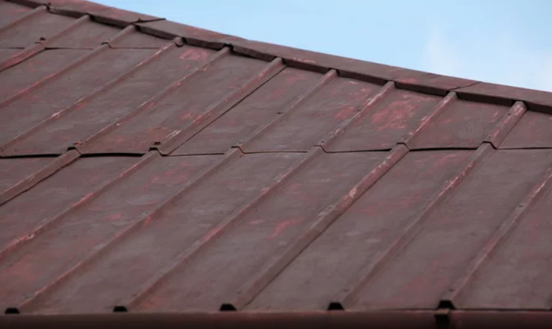 A metal roof surface in a severely deteriorated state.