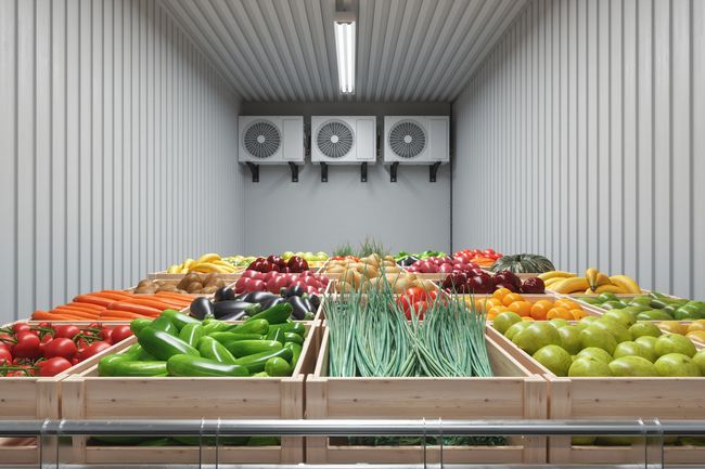 Produce display in a cold storage room; vegetables and fruits in wooden crates. Produce display in a cold storage room; vegetables and fruits in wooden crates.