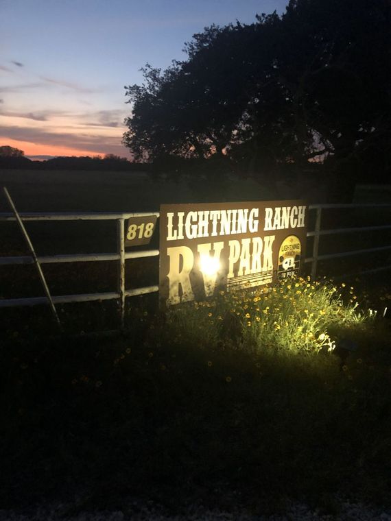 A lightning ranch rv park sign is lit up at night