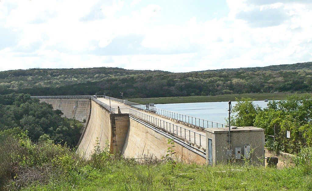 A bridge over a body of water with trees in the background