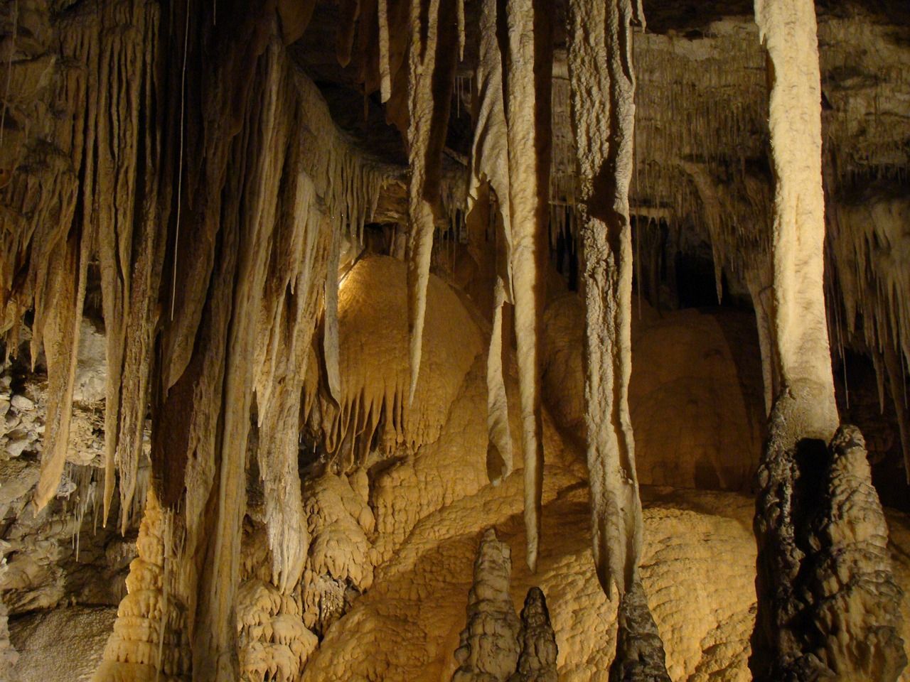 A cave with a lot of icicles hanging from the ceiling.