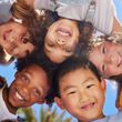 A group of children are standing in a circle and smiling