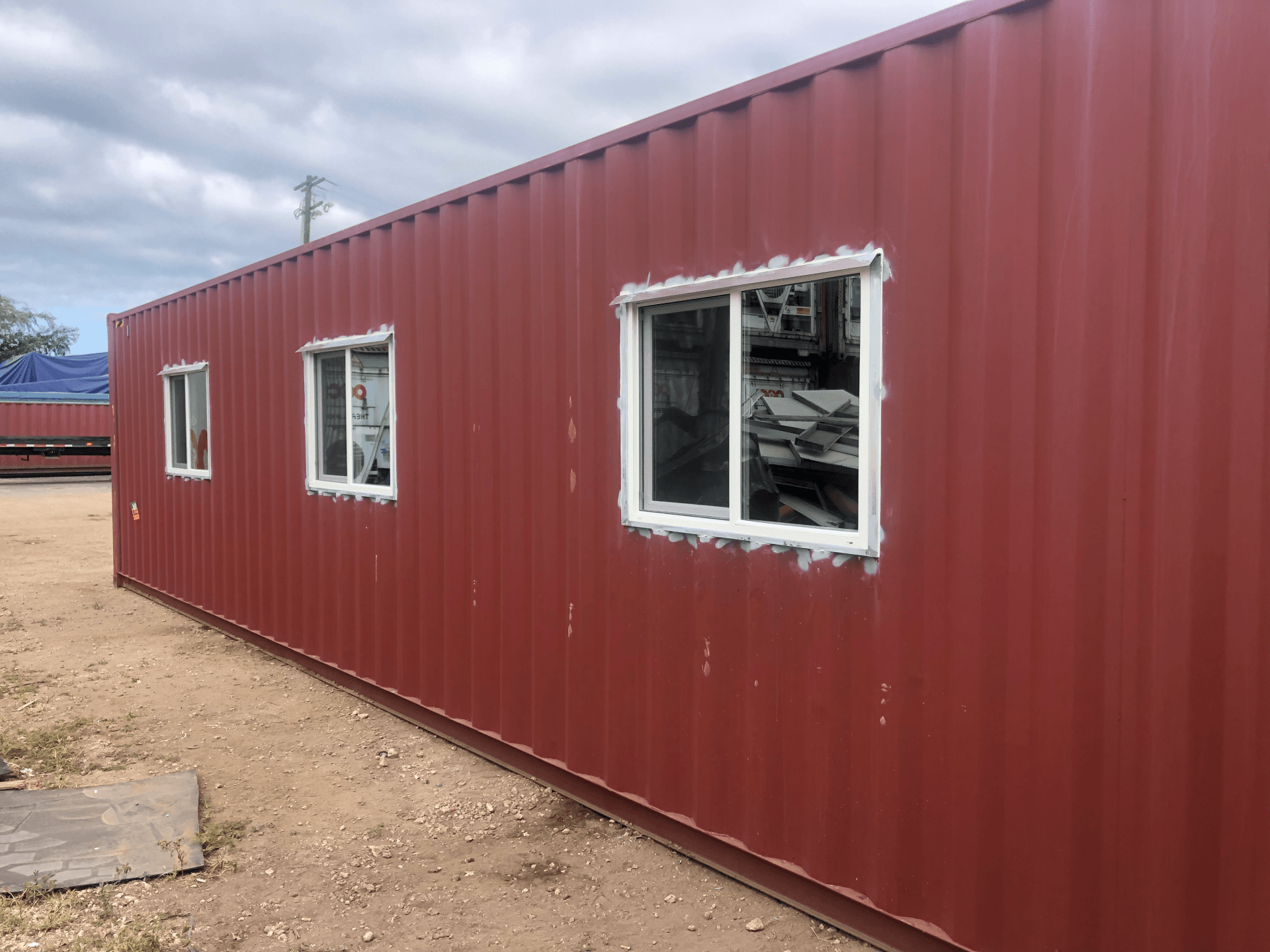 Shipping Container Storage Solution with multiple windows and dark red exterior