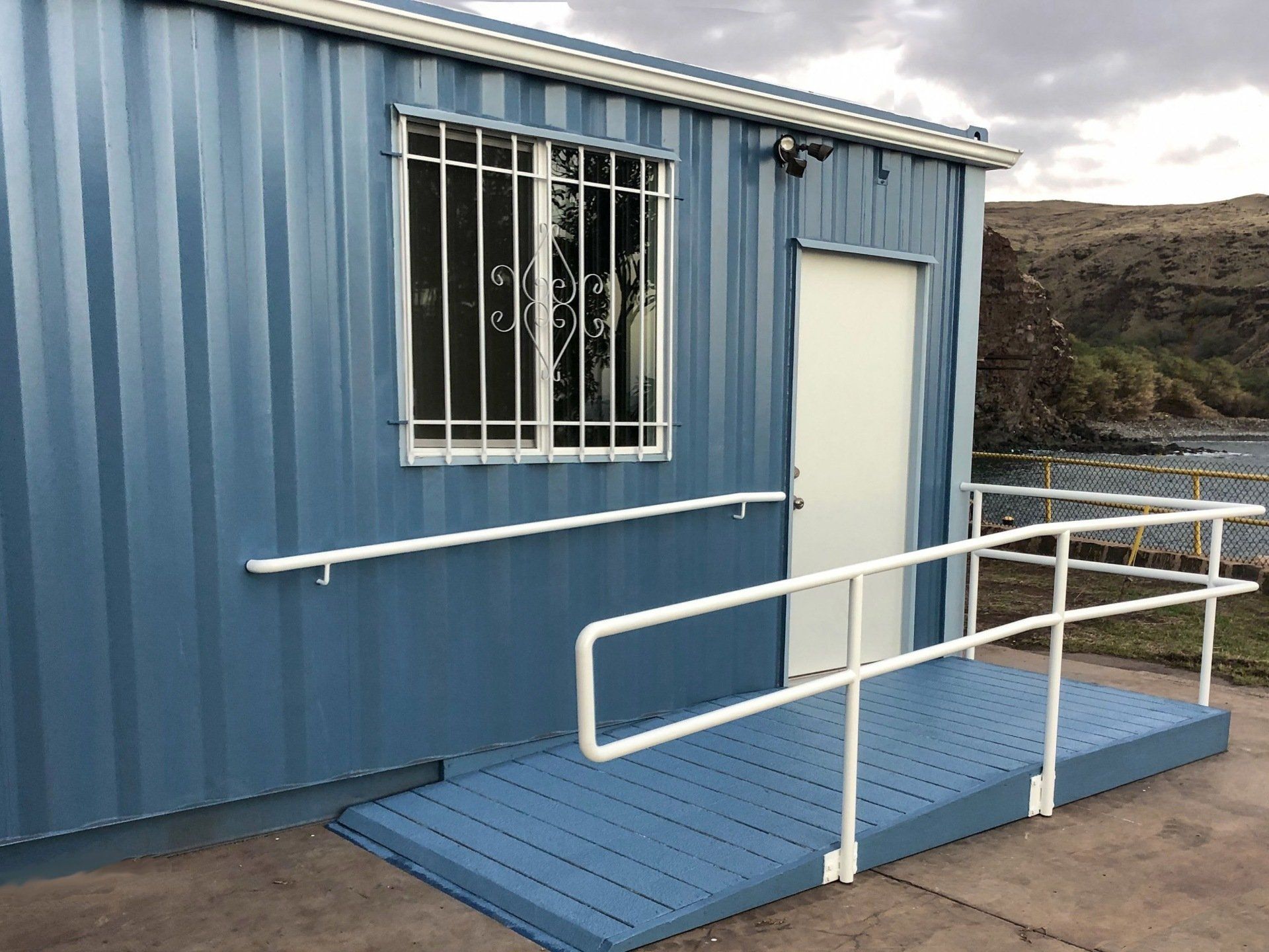 Exterior mobile office with ramp and railings at entrance