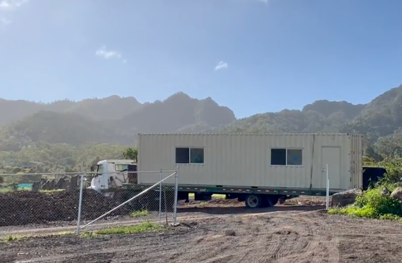 40' Deluxe shipping container office being delivered at a remote location.