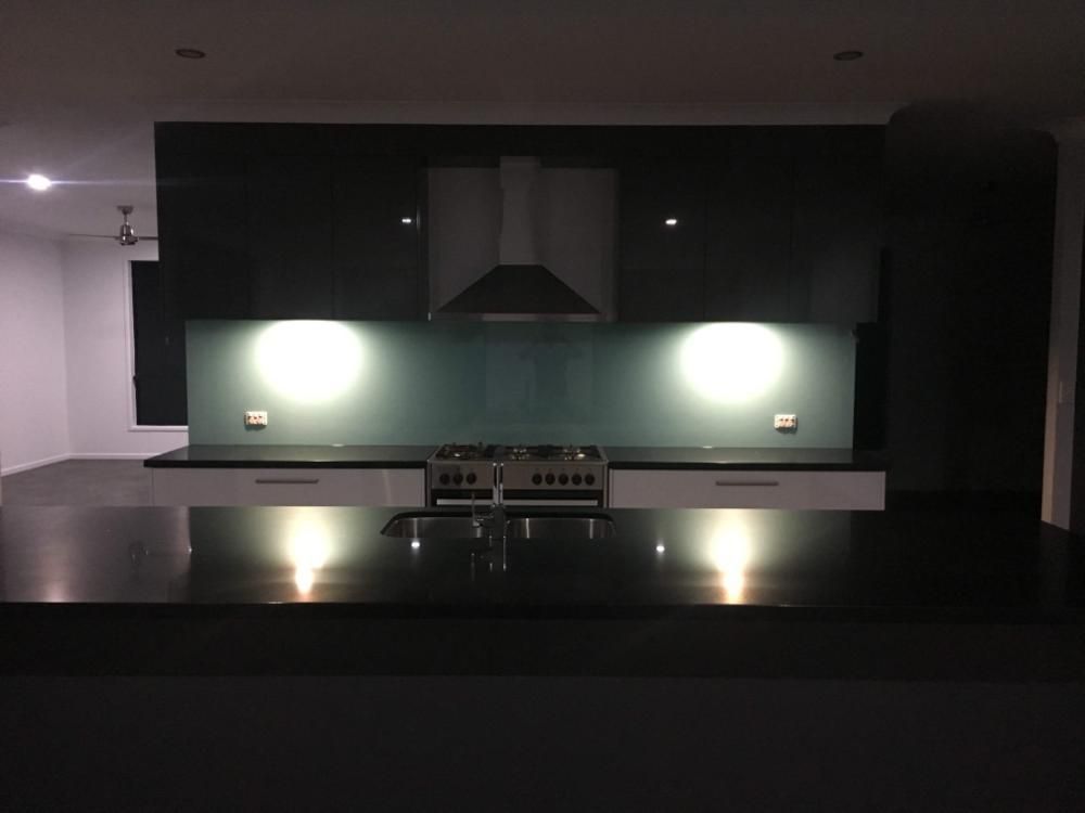 A Kitchen With Black Counter Tops and a Stove Top Oven — GC Joinery in Sunshine Acres, QLD