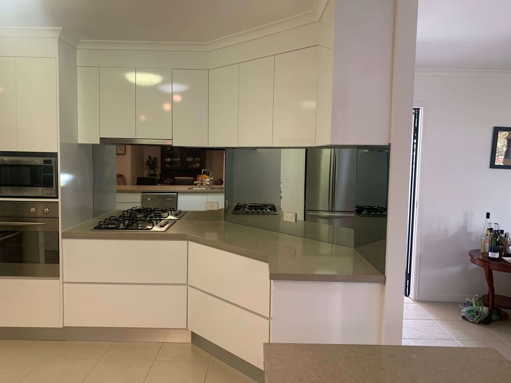 A Kitchen With White Cabinets, Stainless Steel Appliances, and a Stove Top Oven — GC Joinery in Sunshine Acres, QLD