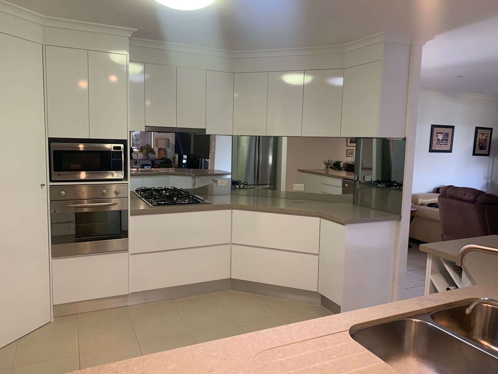 A Kitchen With White Cabinets and Stainless Steel Appliances and a Sink — GC Joinery in Sunshine Acres, QLD