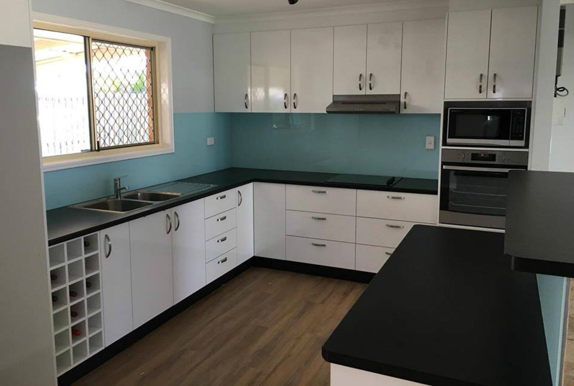A Kitchen With White Cabinets and Black Counter Tops — GC Joinery in Sunshine Acres, QLD