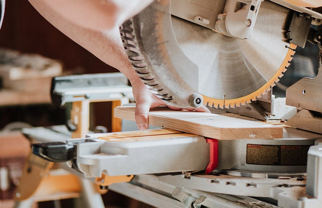 A Person is Cutting a Piece of Wood With a Circular Saw — GC Joinery in Sunshine Acres, QLD