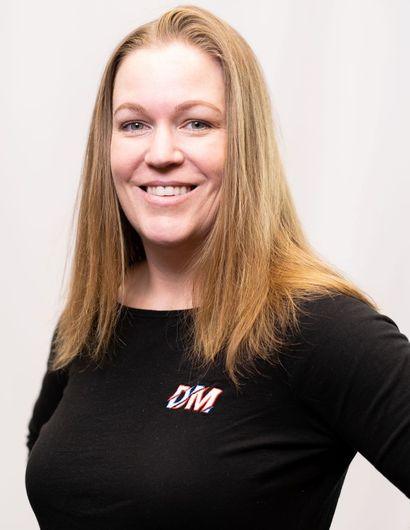 A woman is wearing a black shirt with the word dm on it.