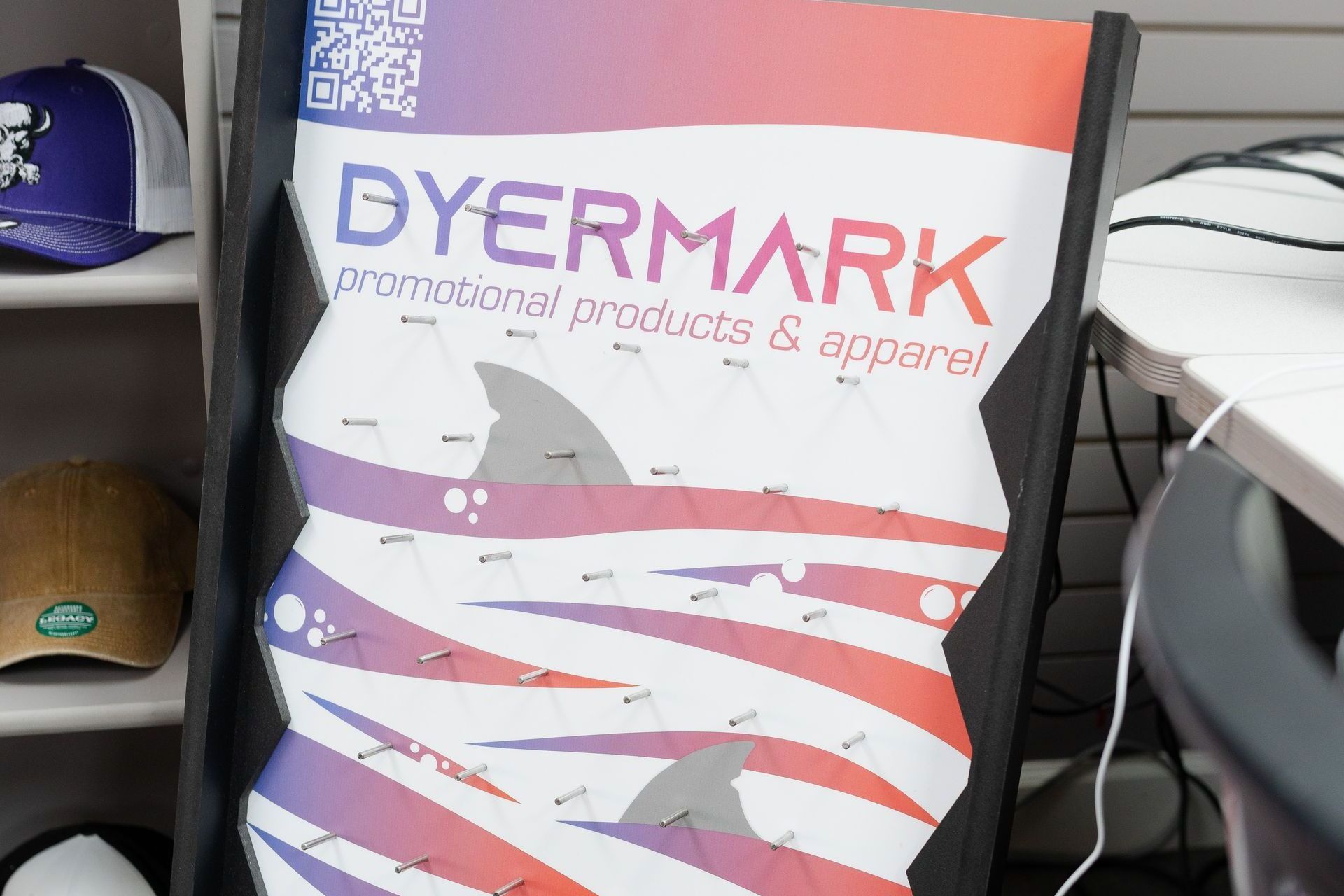 A poster for dyermark promotional products and apparel is sitting on a desk.