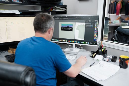 A man is sitting at a desk in front of a computer screen.