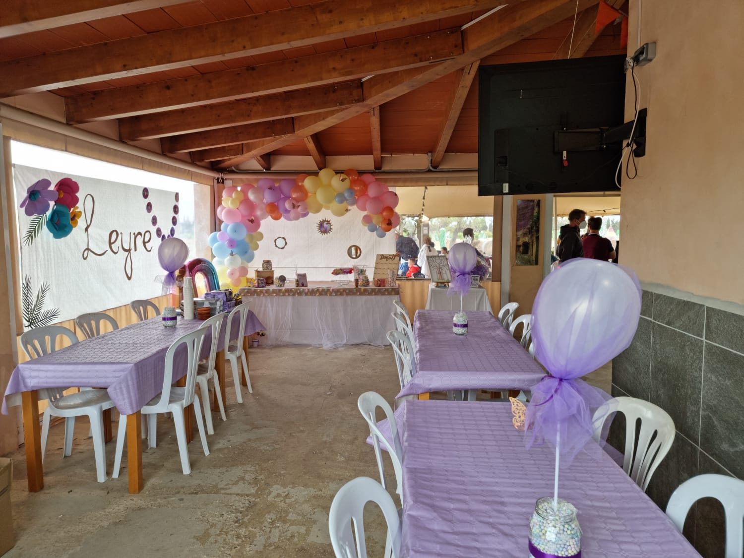 Una sala con mesas y sillas decoradas para una fiesta de cumpleaños.