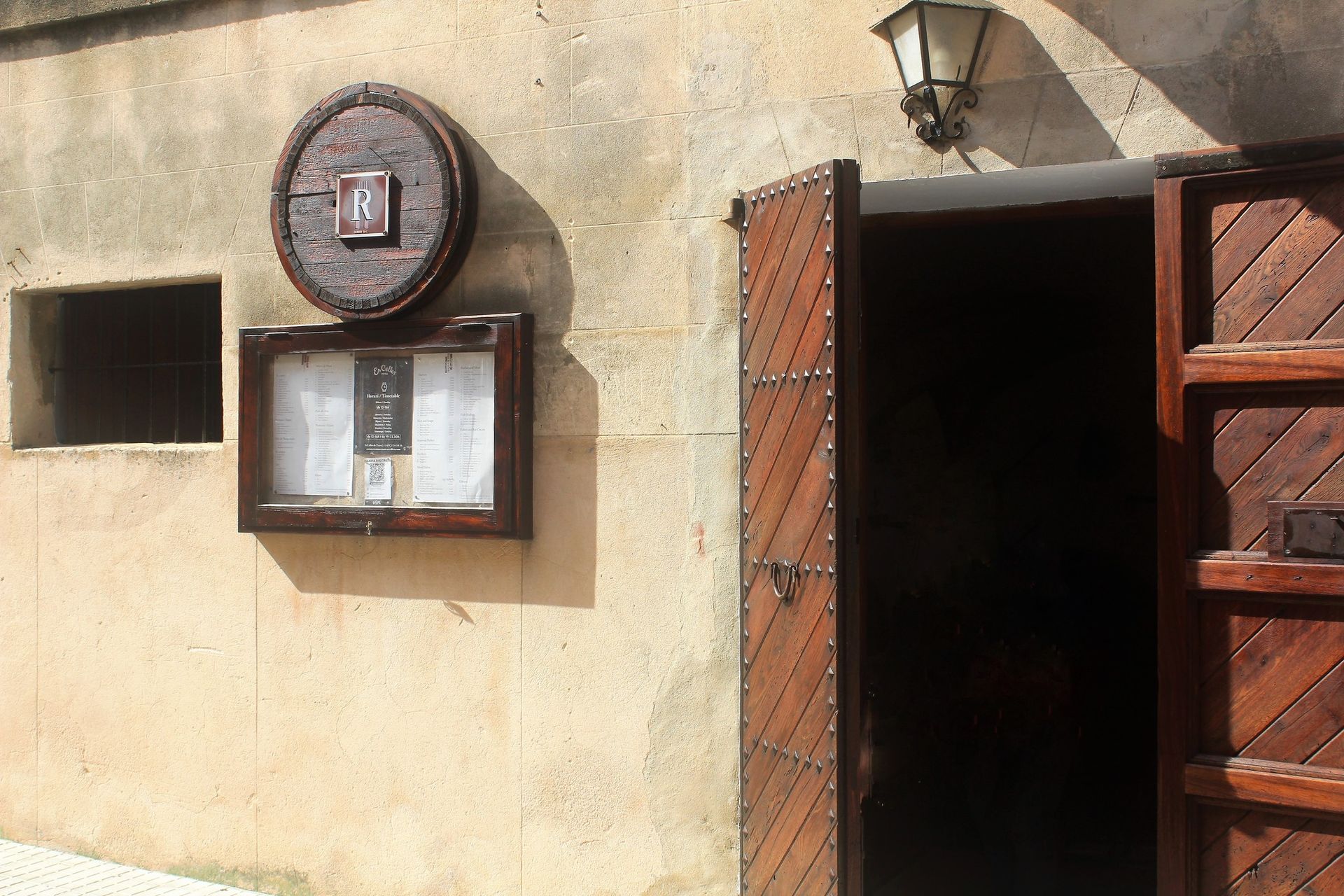 Un edificio con una puerta de madera y un cartel en la pared.