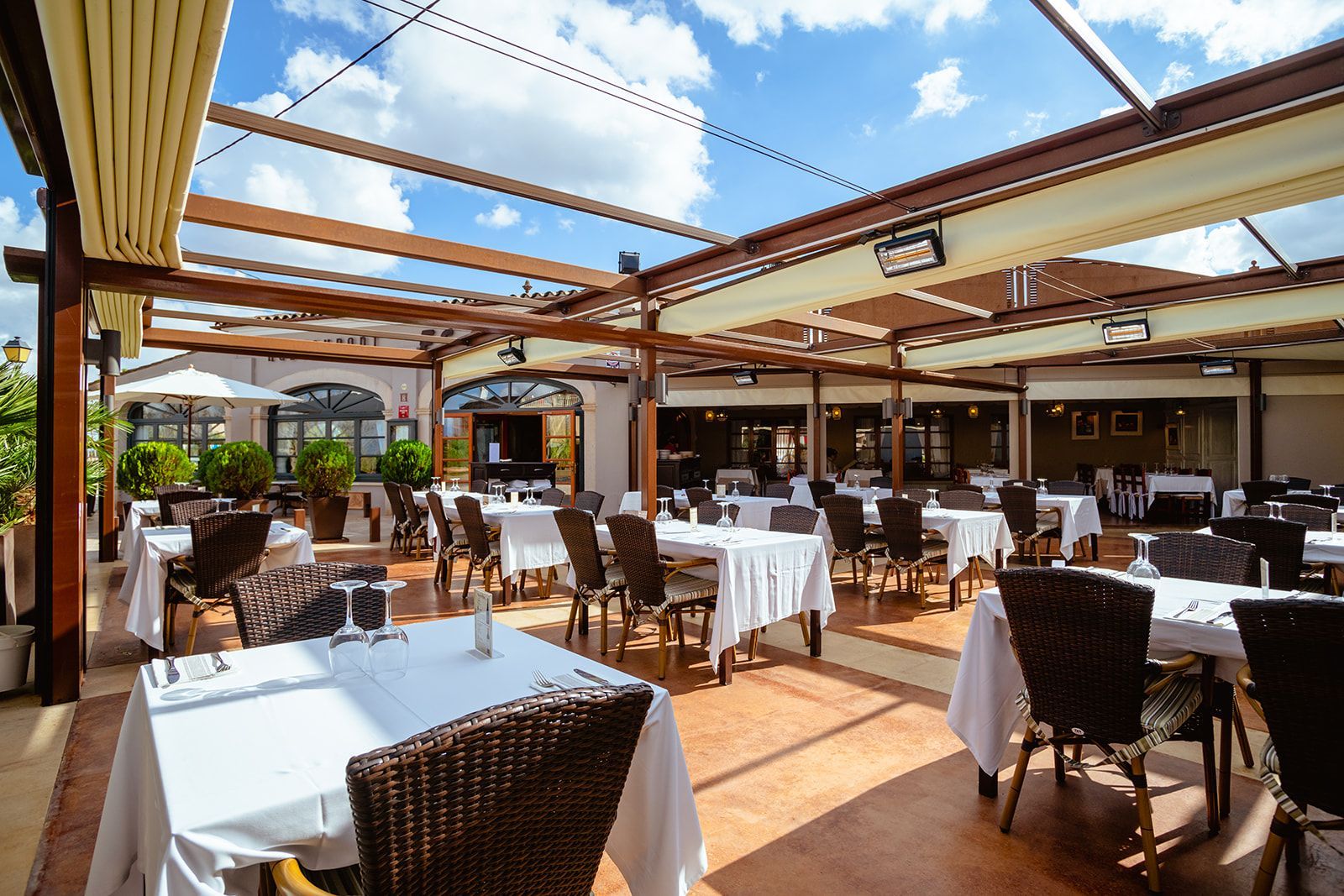 Un restaurante con mesas y sillas bajo un dosel.