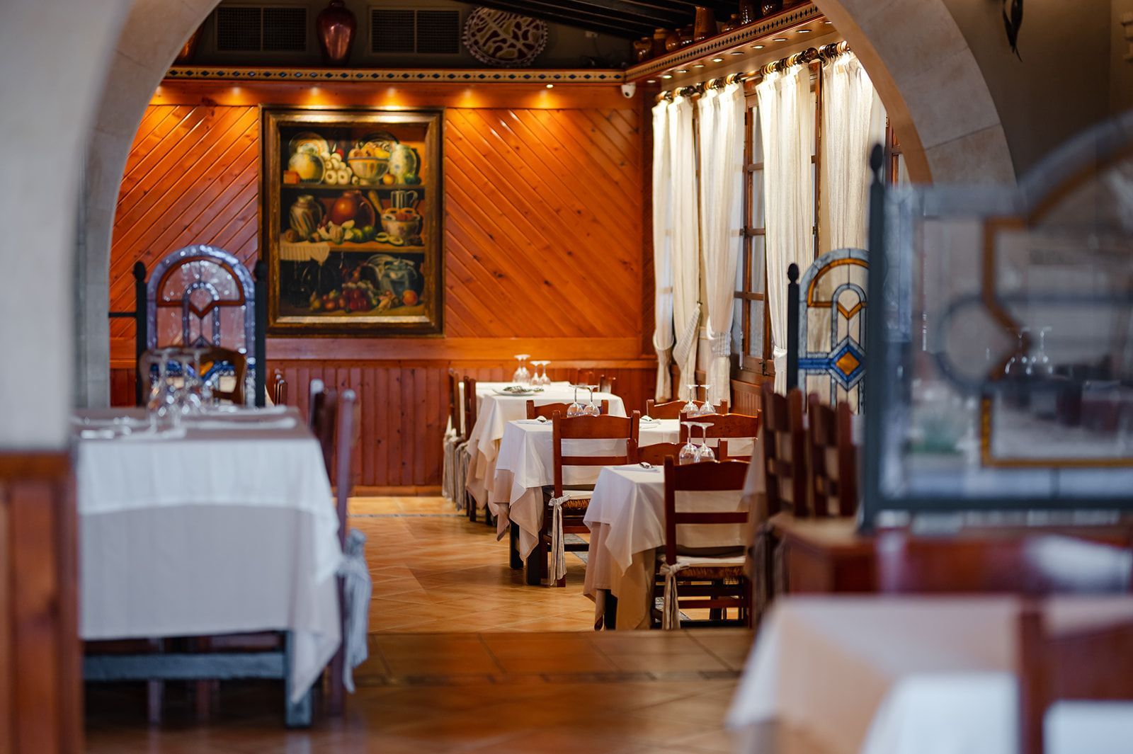 Un restaurante con mesas y sillas y un cuadro en la pared.