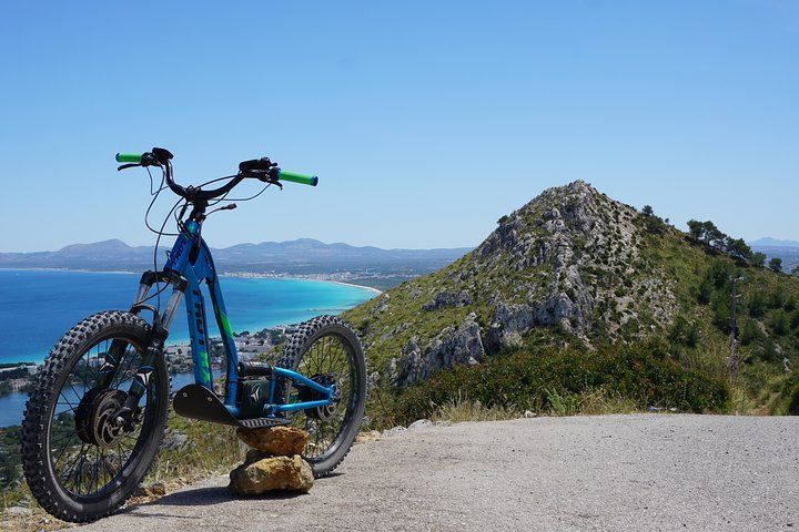Una bicicleta está estacionada sobre una roca al costado de una carretera.