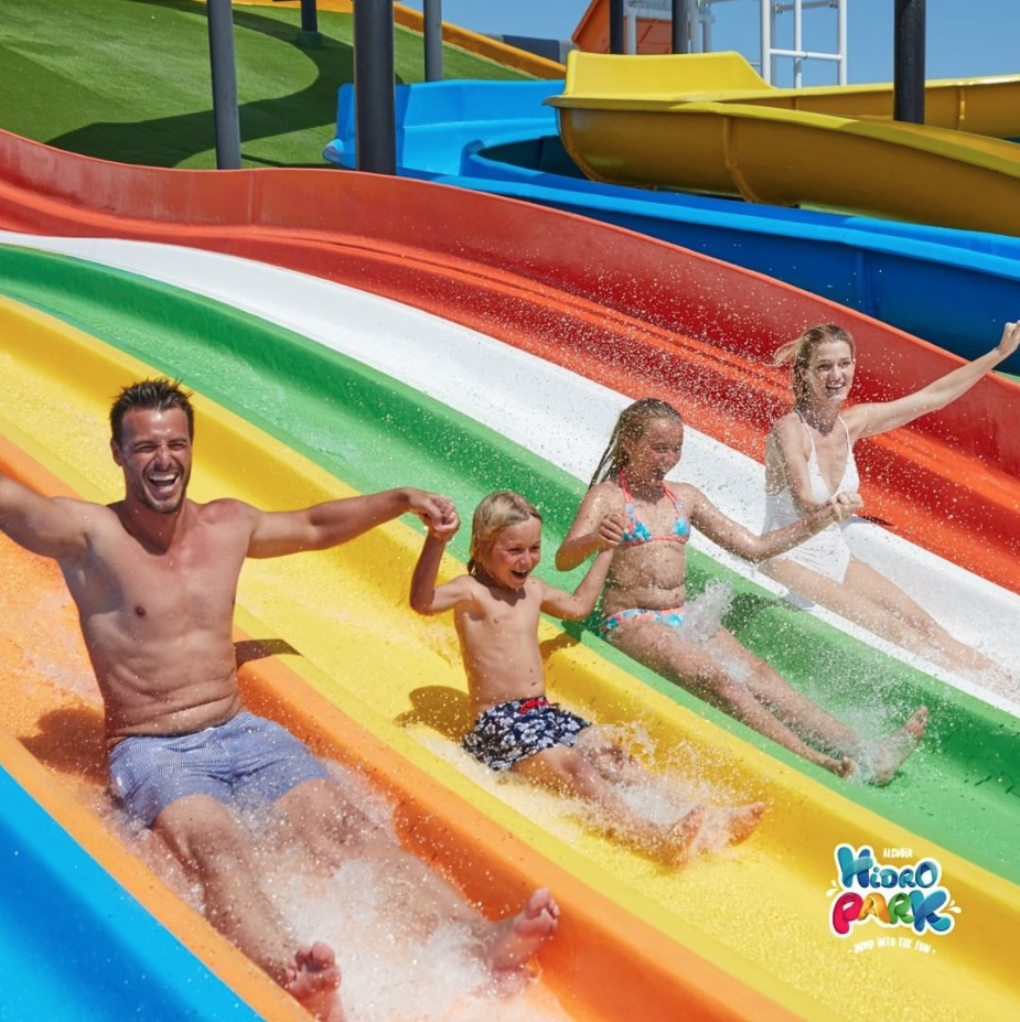 Un grupo de personas se desliza por un tobogán de agua en un parque acuático.