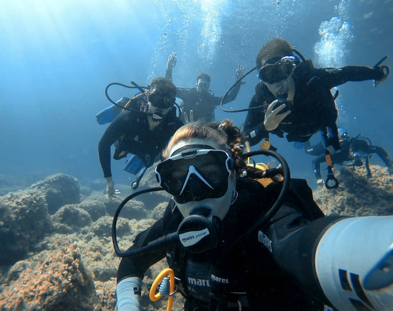Un grupo de buceadores se toma un selfie bajo el agua.