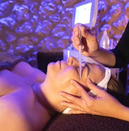Una mujer está recibiendo un tratamiento facial en un spa.