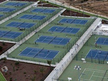 Una vista aérea de una cancha de tenis llena de gente jugando tenis.