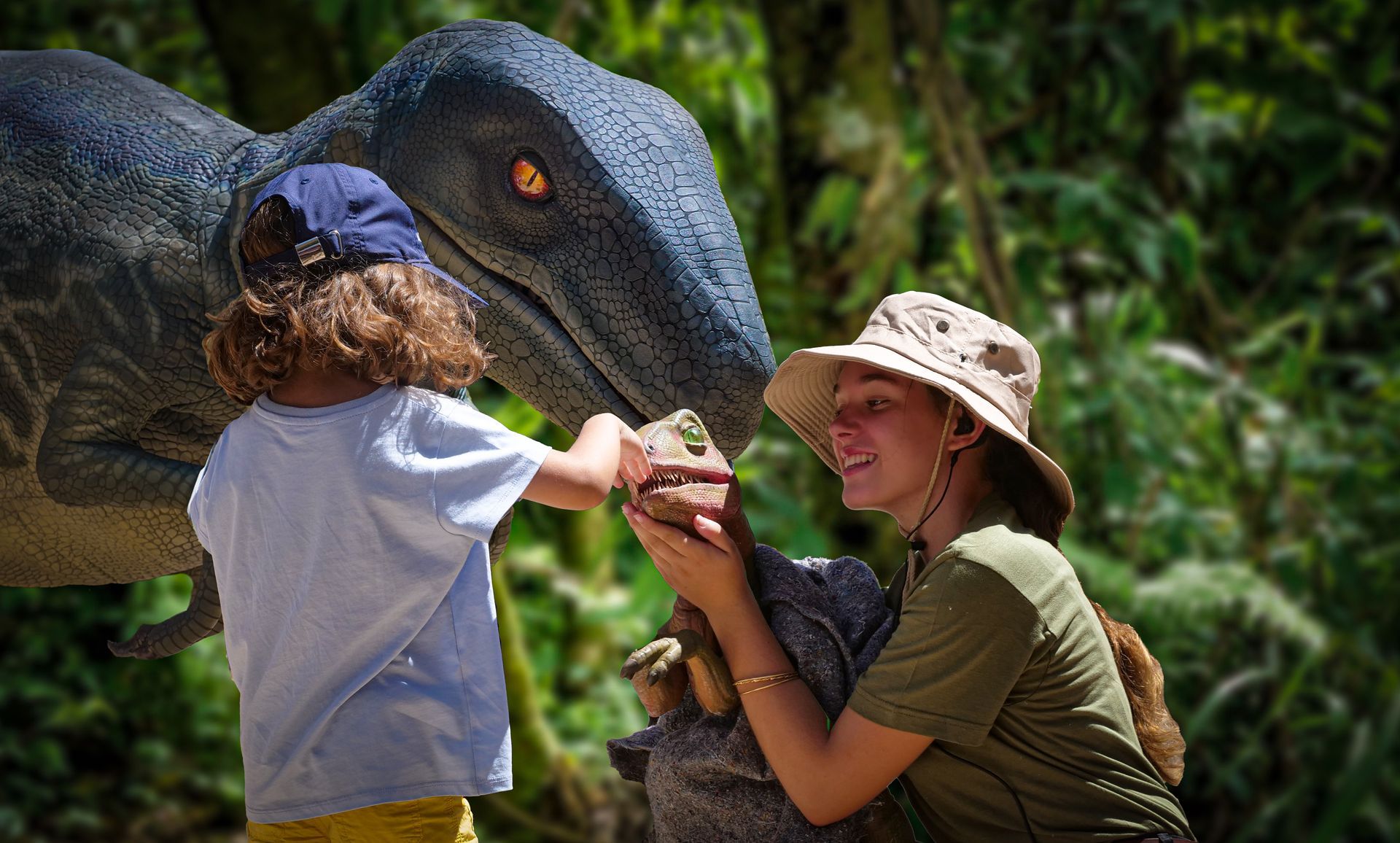 Una mujer y un niño están de pie junto a una estatua de dinosaurio.