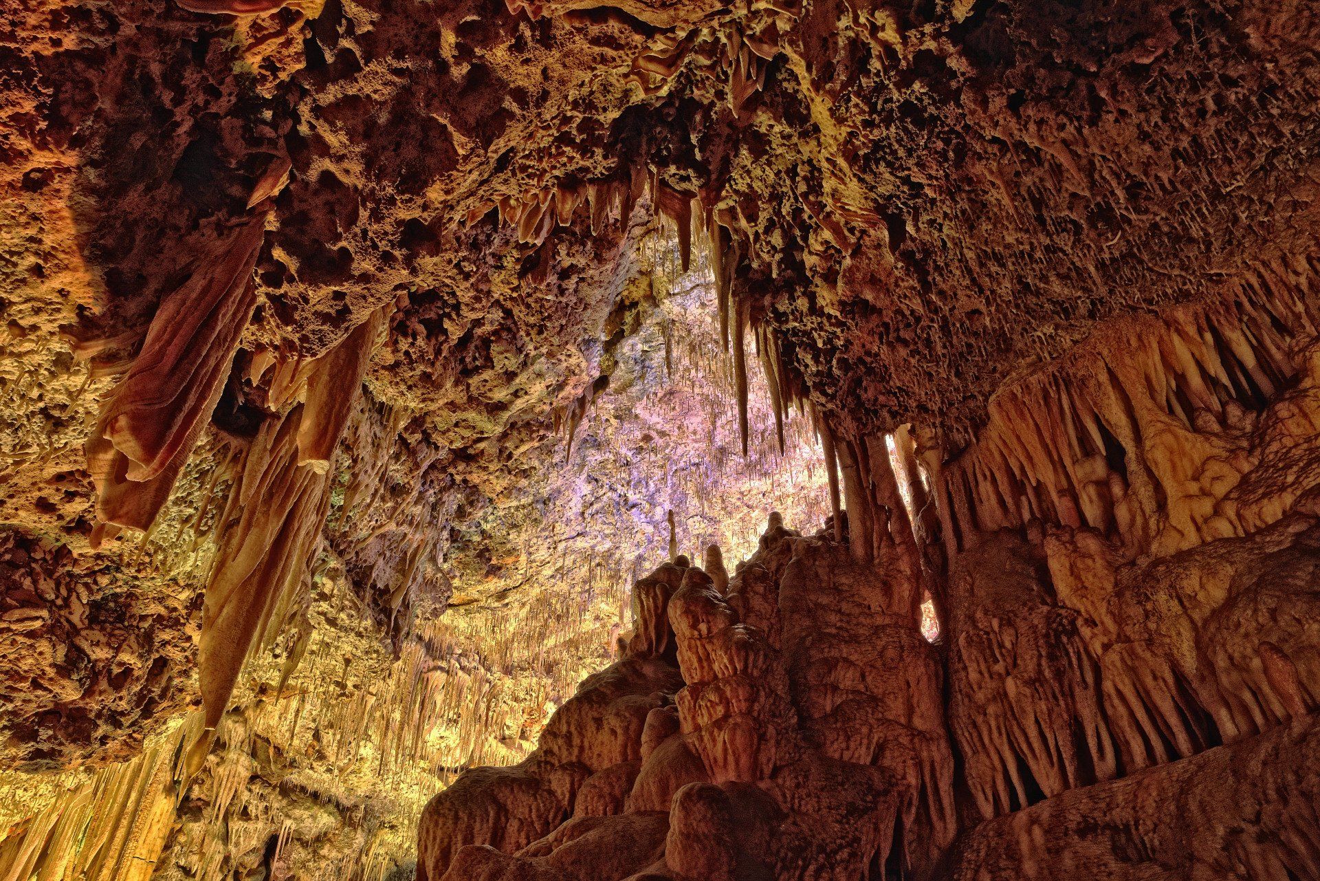 Mirando hacia el techo de una cueva con muchas estalagmitas colgando de él.