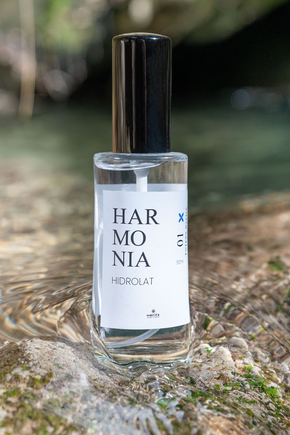 Una botella de perfume está sobre una roca.