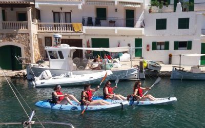 Un grupo de personas están remando en kayaks en un puerto.