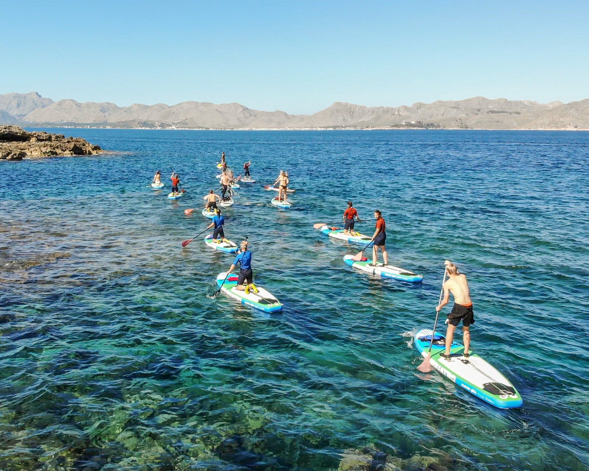 Un grupo de personas están montando tablas de remo en el océano.